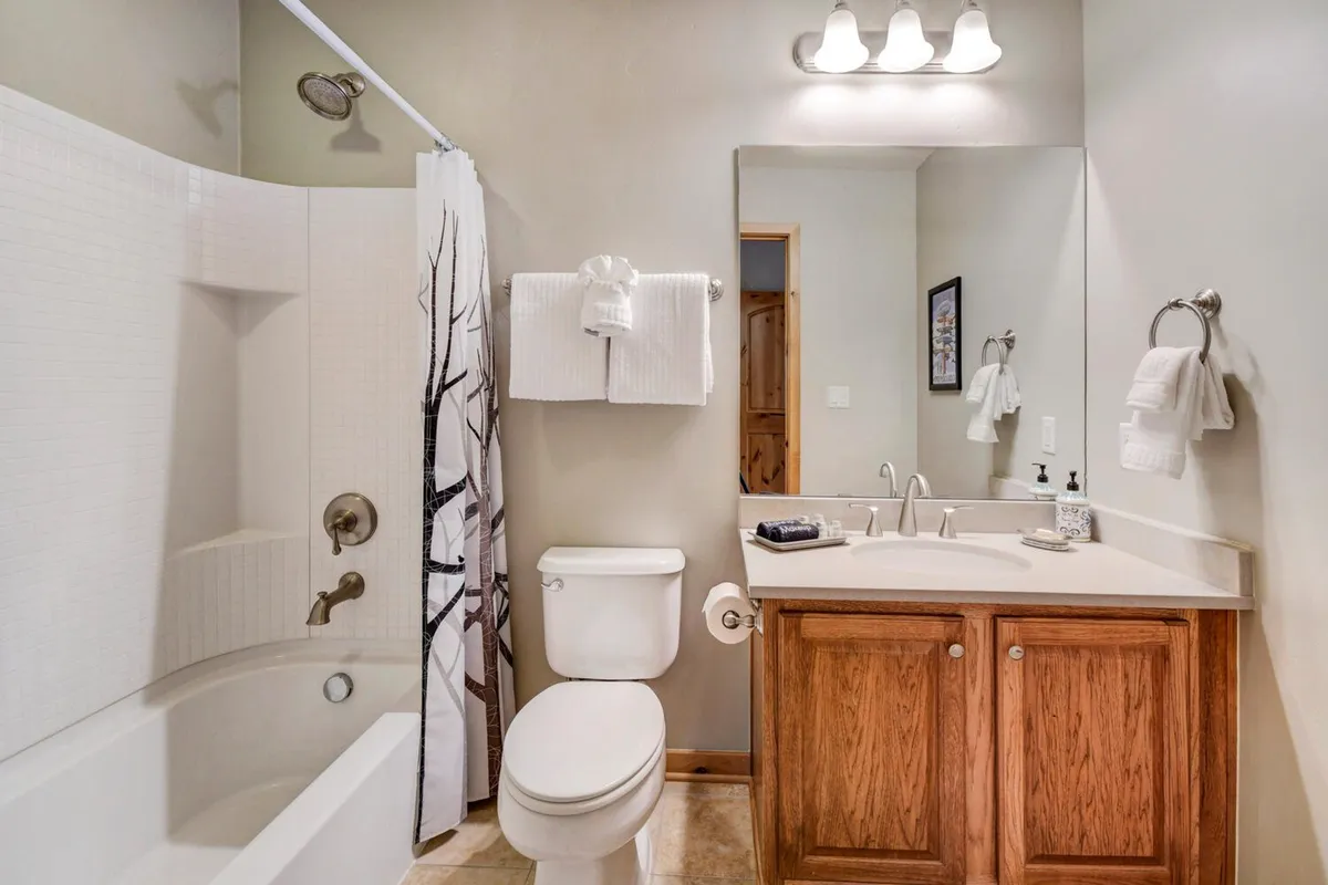 A bright and modern bathroom with a spacious bathtub, sleek sink, and large mirror. The soothing palette and clean lines contribute to a spa-like ambiance, inviting relaxation and rejuvenation.